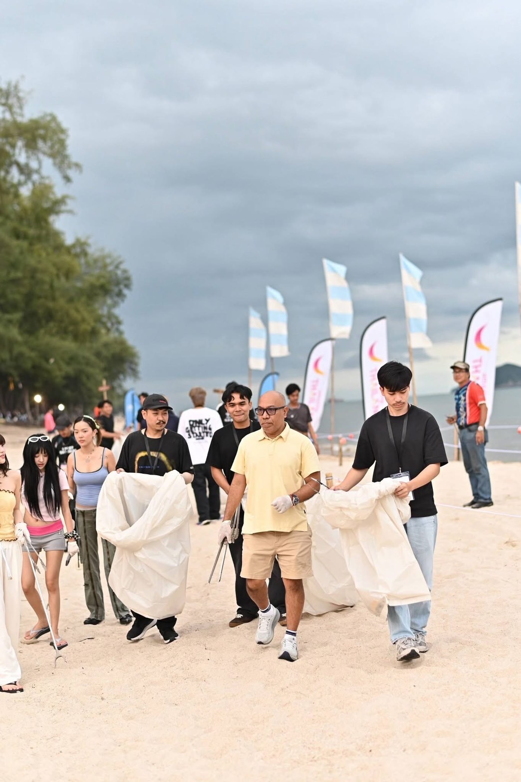 Chanin Aiyarak and volunteers collecting waste along Chalatat Beach, Songkhla, during Amazing Multi-Racing Festival 2026